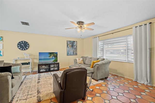 living room with ceiling fan and ornamental molding