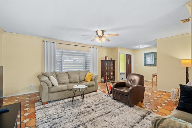 tiled living room with ceiling fan and crown molding