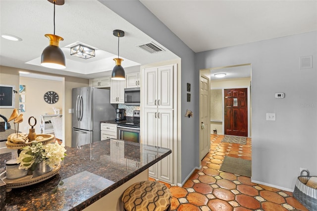 kitchen with decorative backsplash, kitchen peninsula, hanging light fixtures, appliances with stainless steel finishes, and white cabinets