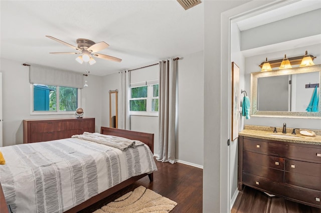 bedroom with ceiling fan, sink, and dark wood-type flooring