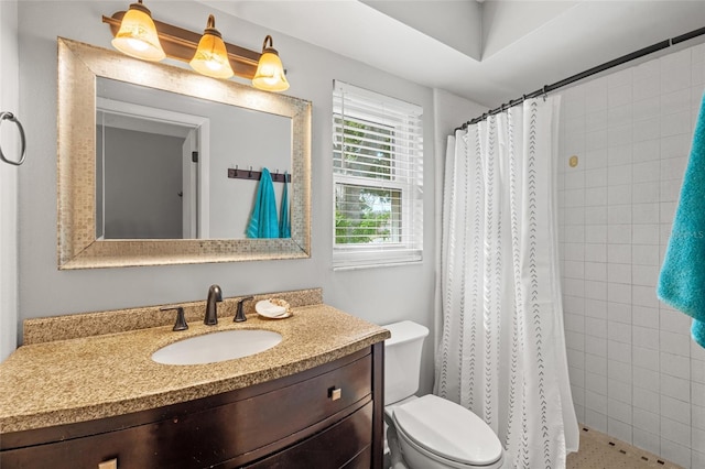 bathroom featuring toilet, vanity, and a shower with curtain