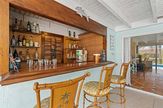 bar featuring tile patterned floors and beamed ceiling