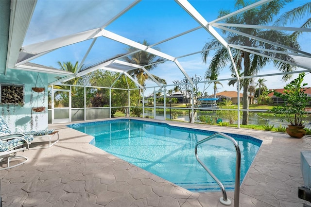 view of swimming pool with glass enclosure, a patio area, and a water view