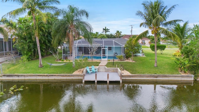 rear view of property with a lanai, a water view, and a yard