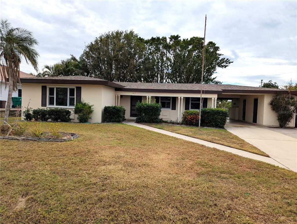 ranch-style home with a front yard and a carport