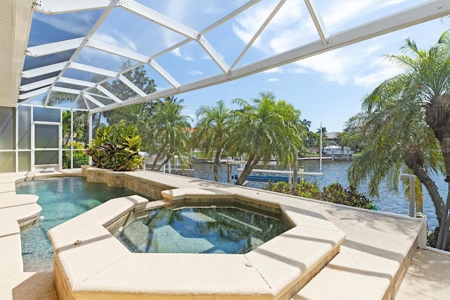 view of pool featuring an in ground hot tub, glass enclosure, and a water view