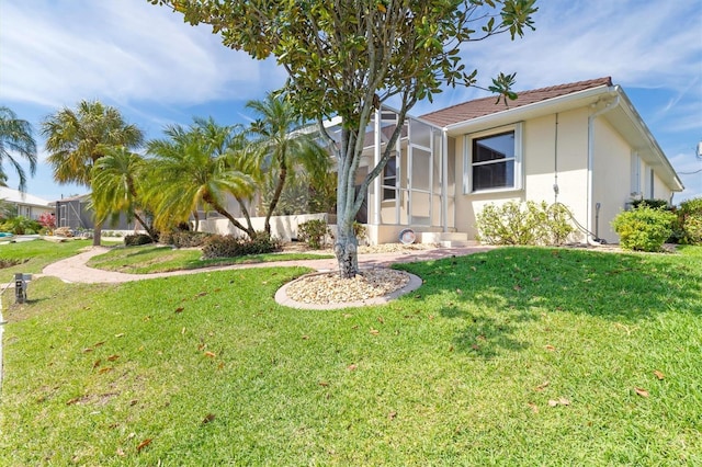 view of front of property featuring a front lawn and glass enclosure