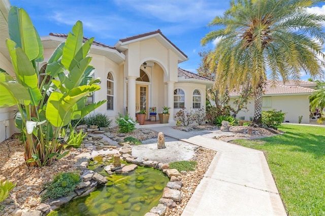 mediterranean / spanish home featuring a front lawn