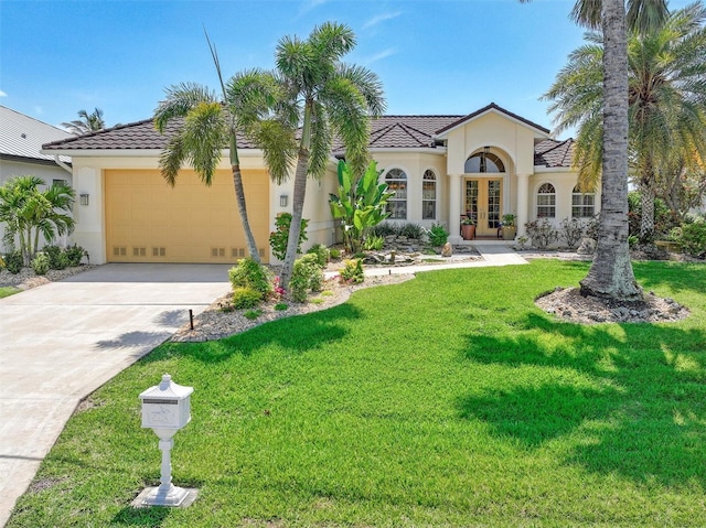 mediterranean / spanish-style house with a front lawn, a garage, and french doors