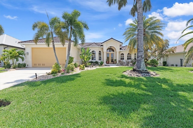 mediterranean / spanish home with a front yard, a garage, and french doors