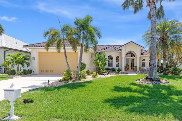 mediterranean / spanish home with a front lawn, french doors, and a garage