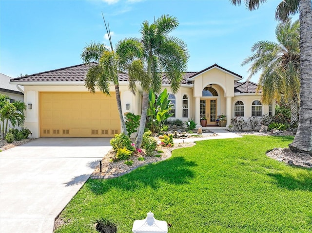 mediterranean / spanish house featuring a front lawn, french doors, and a garage