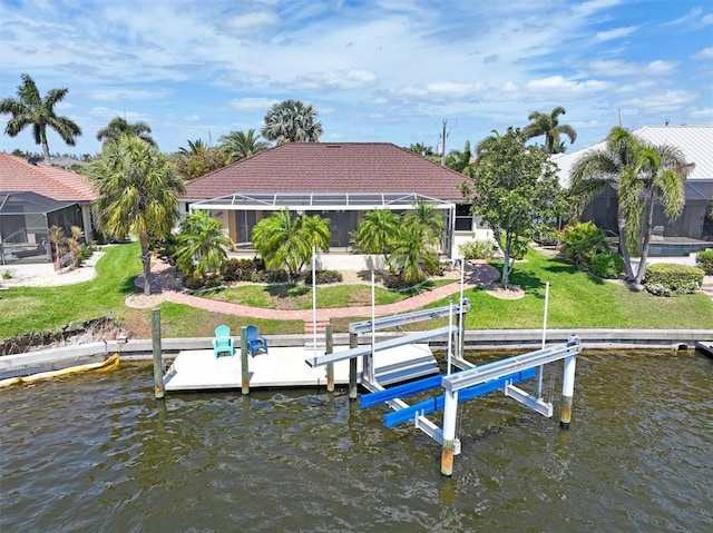 dock area with glass enclosure, a lawn, and a water view