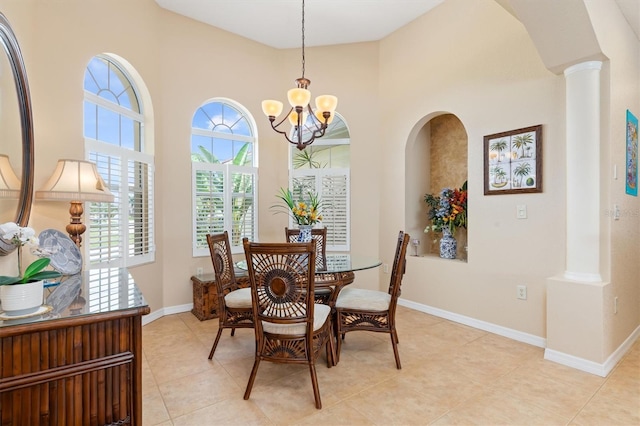 dining area featuring light tile patterned floors, a chandelier, and decorative columns