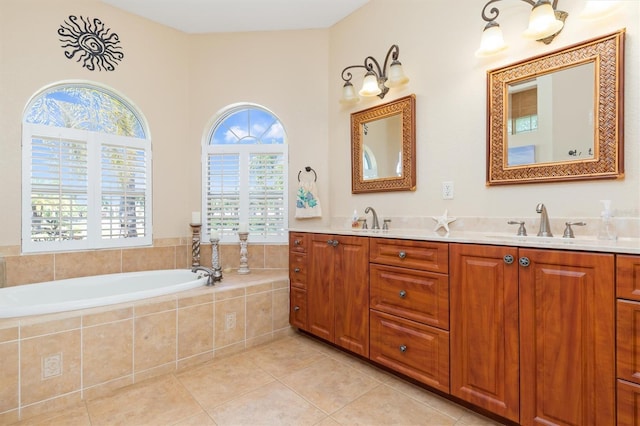 bathroom featuring tiled bath, vanity, and tile patterned flooring