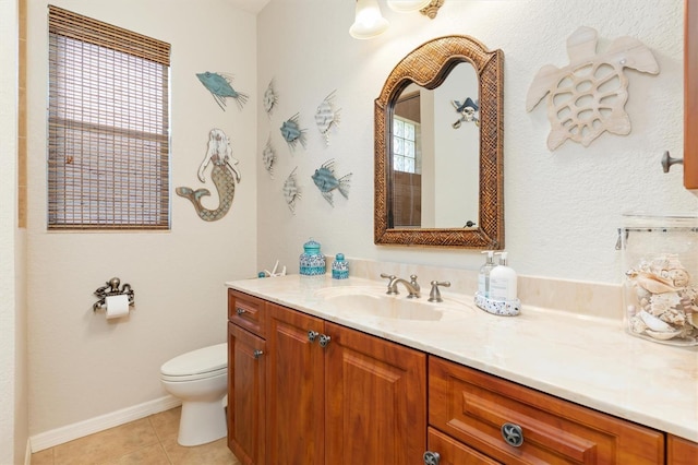 bathroom featuring toilet, vanity, tile patterned flooring, and a healthy amount of sunlight