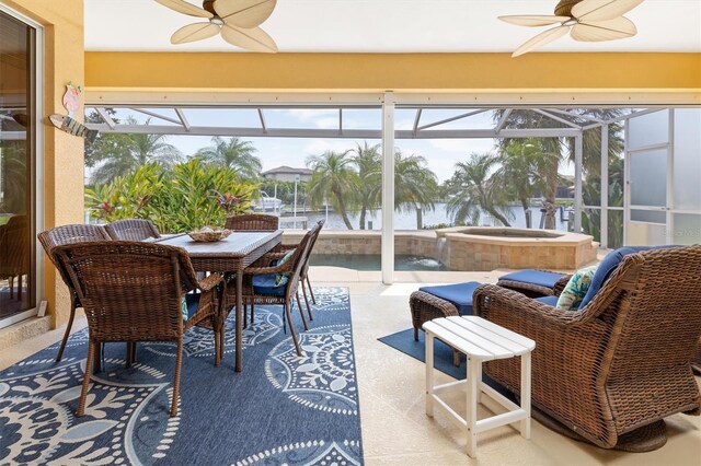 sunroom with ceiling fan, a healthy amount of sunlight, and a water view