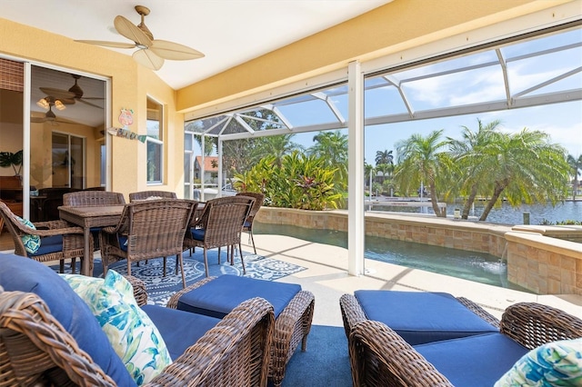 sunroom with a water view, ceiling fan, vaulted ceiling, and a swimming pool