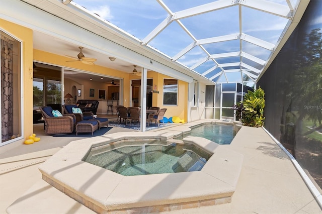 view of swimming pool featuring glass enclosure, ceiling fan, outdoor lounge area, an in ground hot tub, and a patio