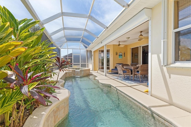 view of pool featuring a patio area, an in ground hot tub, glass enclosure, and ceiling fan