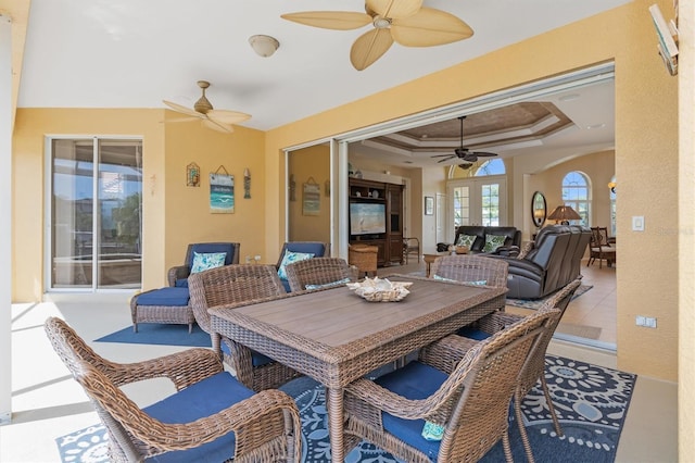 interior space with tile patterned floors, french doors, ornamental molding, ceiling fan, and a tray ceiling