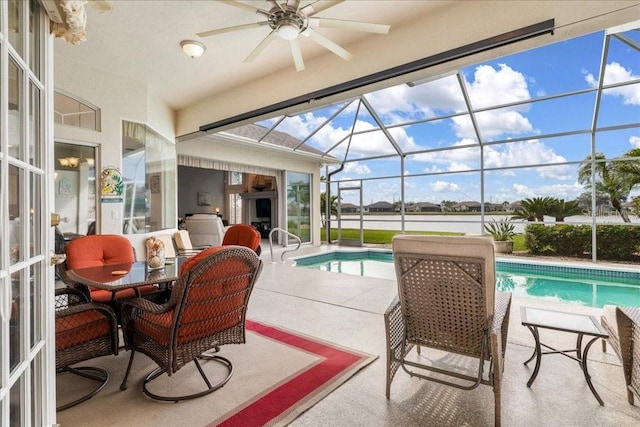 view of pool featuring glass enclosure, a patio area, and ceiling fan