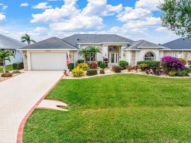 ranch-style house featuring a front lawn and a garage