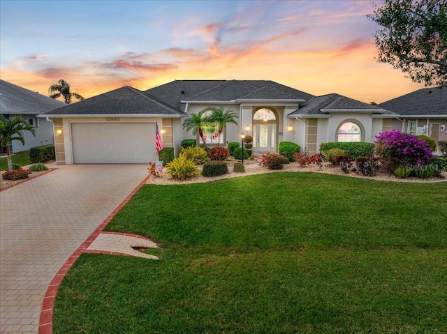 view of front of home featuring a garage and a yard