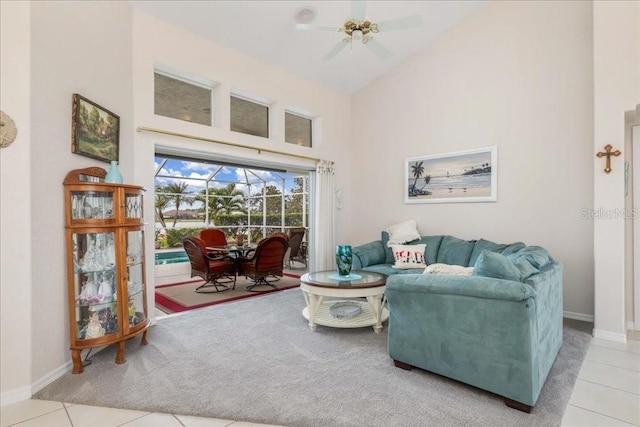 living room with ceiling fan, light tile patterned flooring, and a high ceiling