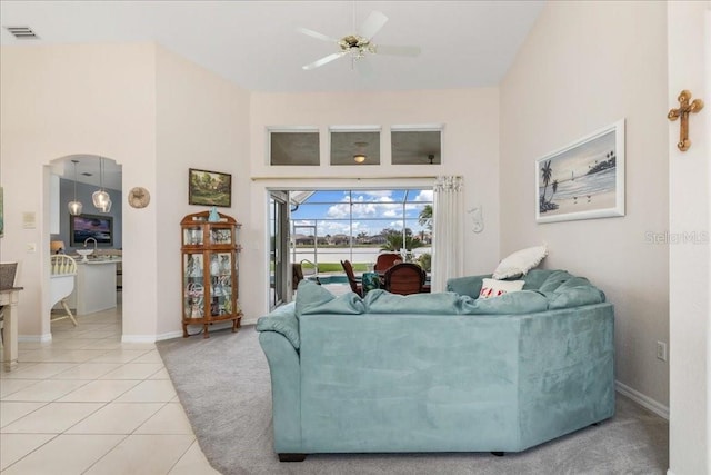 living room featuring ceiling fan, tile patterned flooring, and a towering ceiling