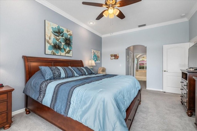 bedroom featuring ceiling fan, light colored carpet, ensuite bathroom, and ornamental molding