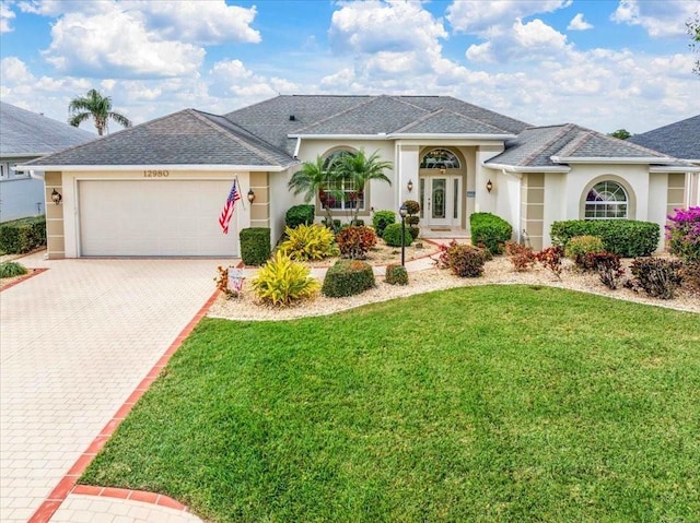 single story home featuring a garage and a front lawn