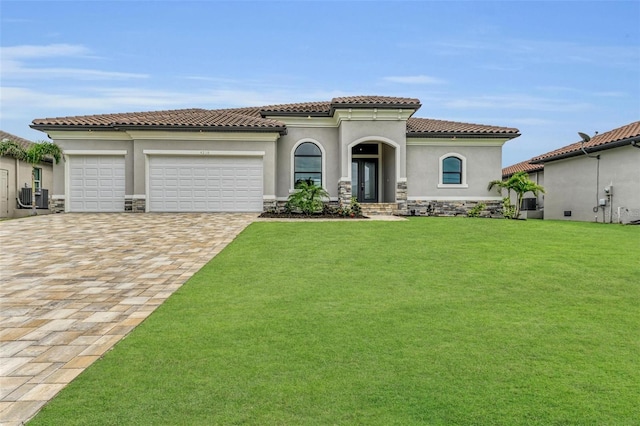 mediterranean / spanish-style house with a garage, central AC unit, and a front lawn