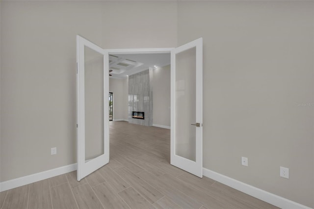 spare room featuring a tile fireplace and french doors