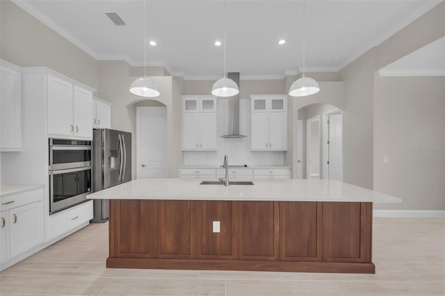 kitchen with sink, hanging light fixtures, stainless steel appliances, white cabinets, and a center island with sink