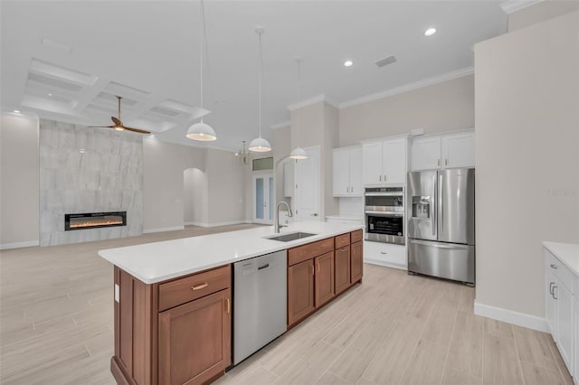 kitchen featuring sink, white cabinetry, stainless steel appliances, coffered ceiling, and a center island with sink