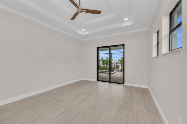 spare room featuring a tray ceiling, ornamental molding, and ceiling fan