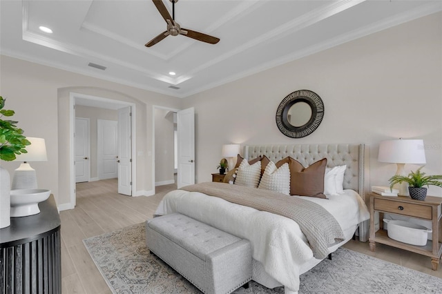 bedroom featuring crown molding, a tray ceiling, and ceiling fan