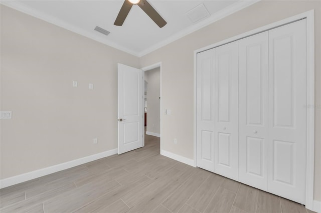 unfurnished bedroom with ornamental molding, ceiling fan, and a closet