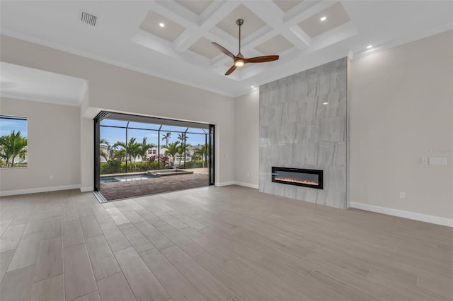 unfurnished living room featuring ceiling fan, a towering ceiling, coffered ceiling, a fireplace, and beamed ceiling