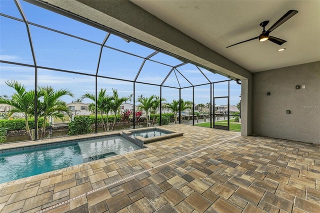 view of swimming pool with an in ground hot tub, ceiling fan, a patio, and glass enclosure