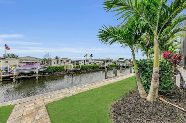 view of dock with a water view and a lawn