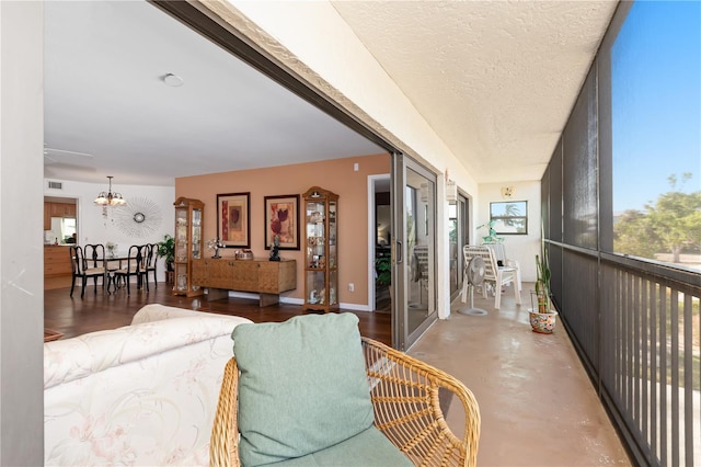 living room featuring a textured ceiling, a chandelier, and concrete flooring