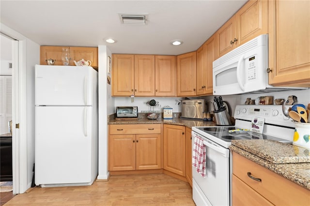 kitchen featuring white appliances, light brown cabinets, light hardwood / wood-style flooring, and stone counters