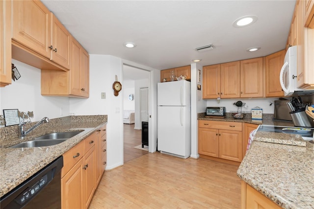 kitchen with light stone countertops, white appliances, light brown cabinets, sink, and light hardwood / wood-style flooring