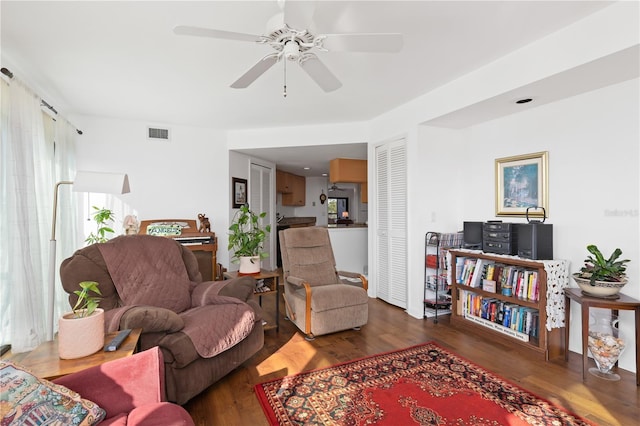 living room featuring ceiling fan and dark hardwood / wood-style floors