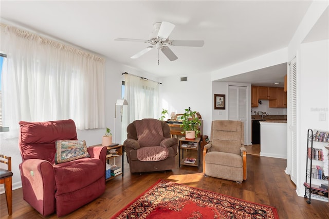 living room featuring ceiling fan and dark wood-type flooring