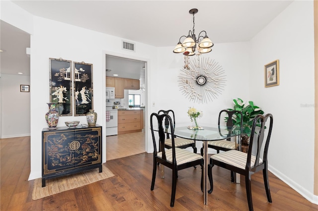 dining space featuring a notable chandelier and dark hardwood / wood-style flooring