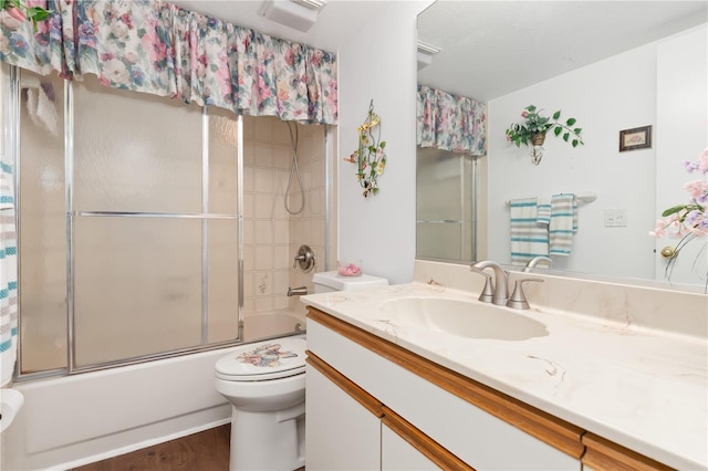 full bathroom featuring toilet, enclosed tub / shower combo, vanity, and hardwood / wood-style floors