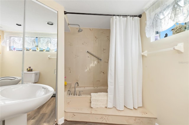 full bathroom with toilet, shower / tub combo, hardwood / wood-style flooring, and sink